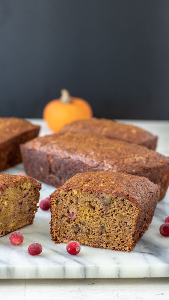 Cut pumpkin quick bread with chunks of cranberry and orange.
