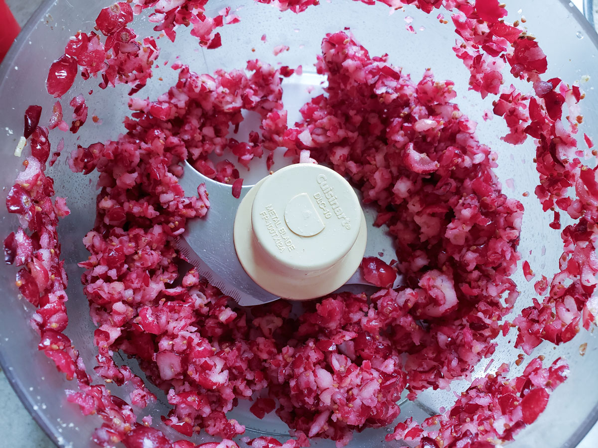Chopped cranberries in the food processor bowl.